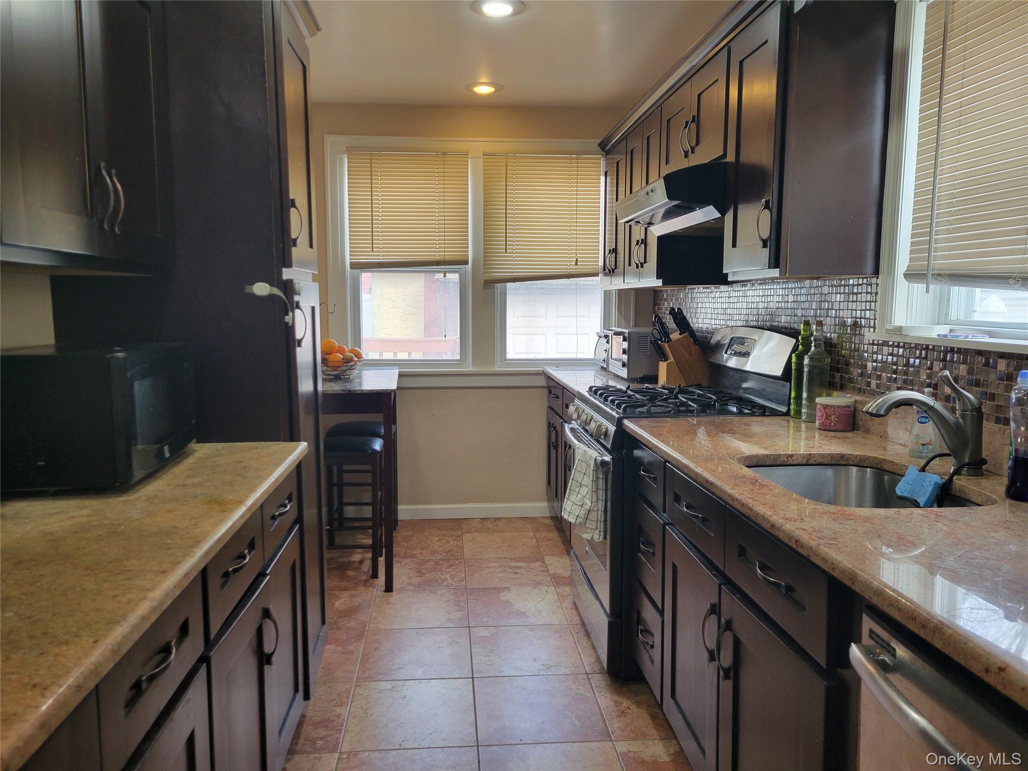 214-19 112th Road Queens, NY 11429 - Photo 7 of 19 a kitchen with a sink stove top oven and cabinets