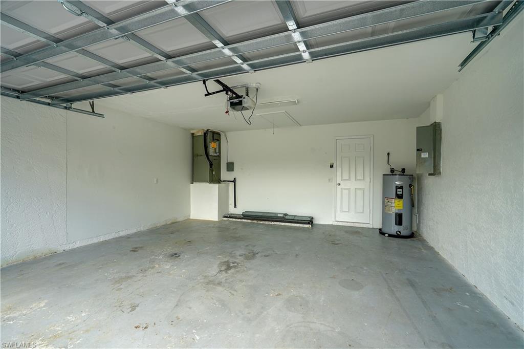 8381 Blackberry Road Fort Myers, FL 33967 - Photo 28 of 36 Garage with electric panel, a garage door opener, and electric water heater