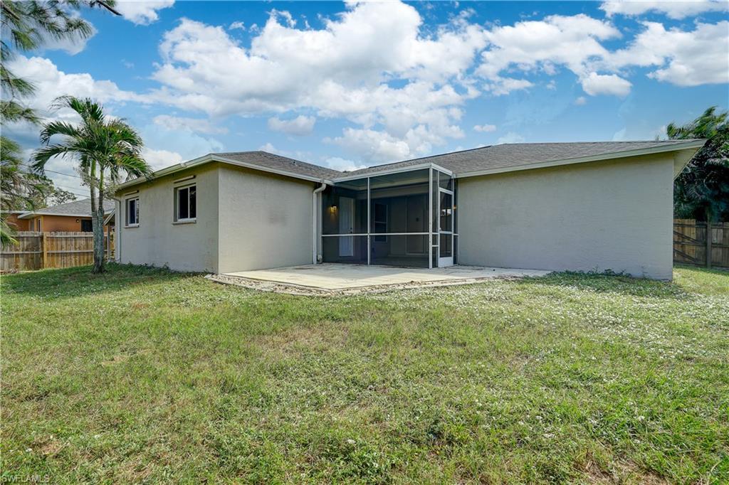 8381 Blackberry Road Fort Myers, FL 33967 - Photo 32 of 36 Back of house with a patio, a sunroom, and a lawn