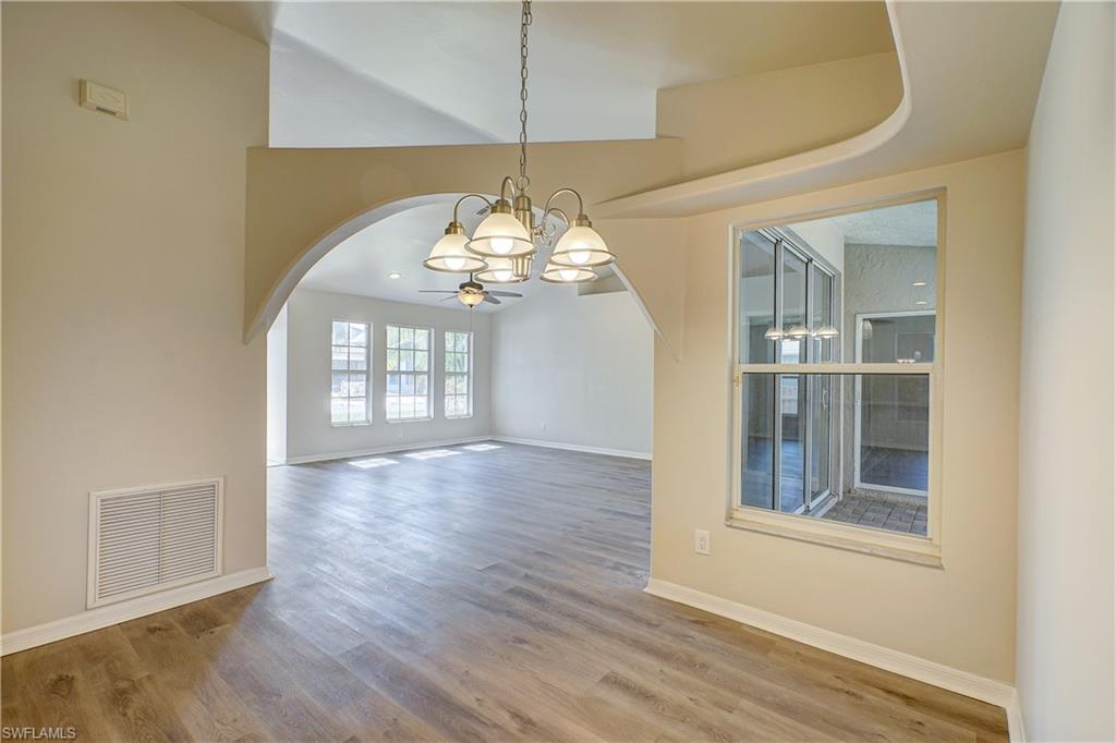 8381 Blackberry Road Fort Myers, FL 33967 - Photo 6 of 36 Unfurnished dining area featuring wood-type flooring and ceiling fan with notable chandelier
