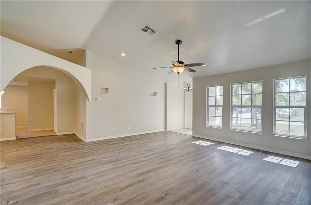 8381 Blackberry Road Fort Myers, FL 33967 - Photo 9 of 36 Unfurnished living room featuring vaulted ceiling, light wood-type flooring, and ceiling fan