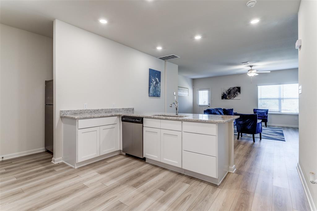 320 Stone Court Princeton, TX 75407 - Photo 3 of 15 a kitchen with sink cabinets and wooden floor