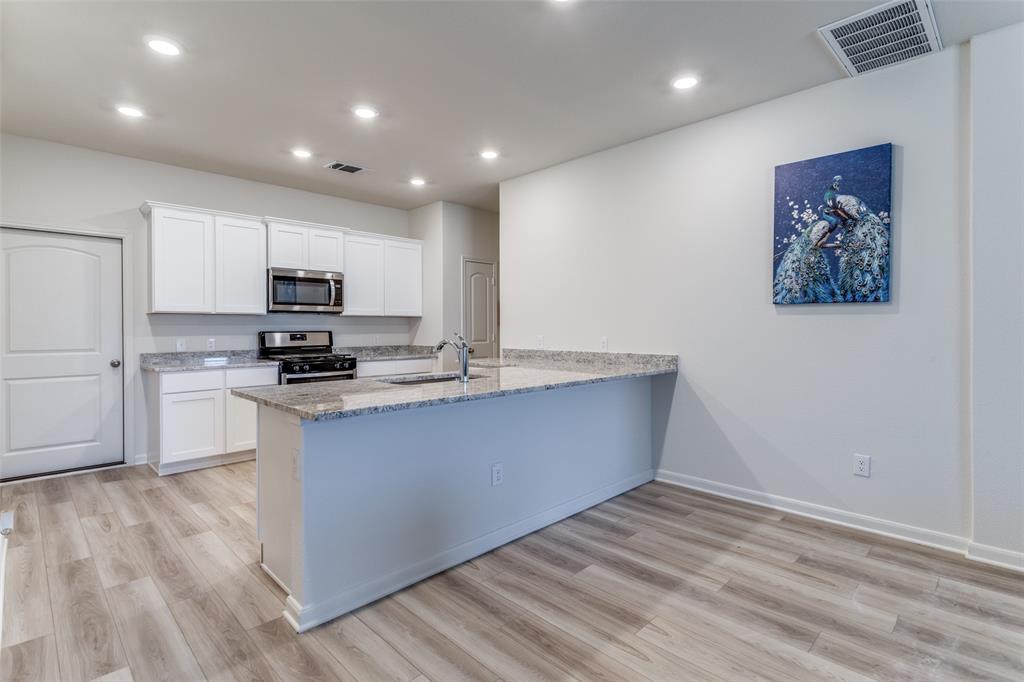 320 Stone Court Princeton, TX 75407 - Photo 6 of 15 a kitchen with stainless steel appliances a refrigerator and a stove top oven