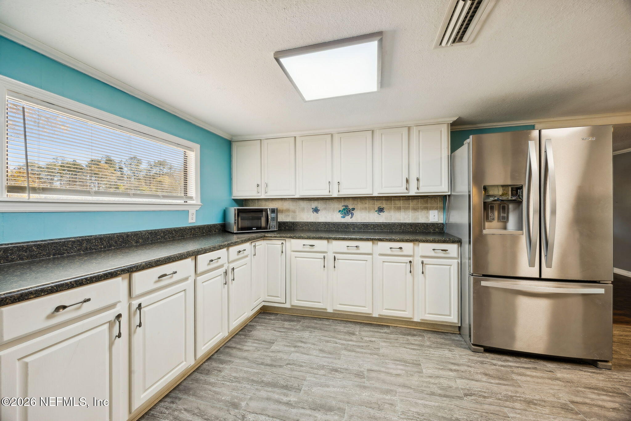 8117 Northwest County Road, Unit 225 Raiford, FL 32083 - Photo 13 of 38 a kitchen with granite countertop white cabinets and stainless steel appliances