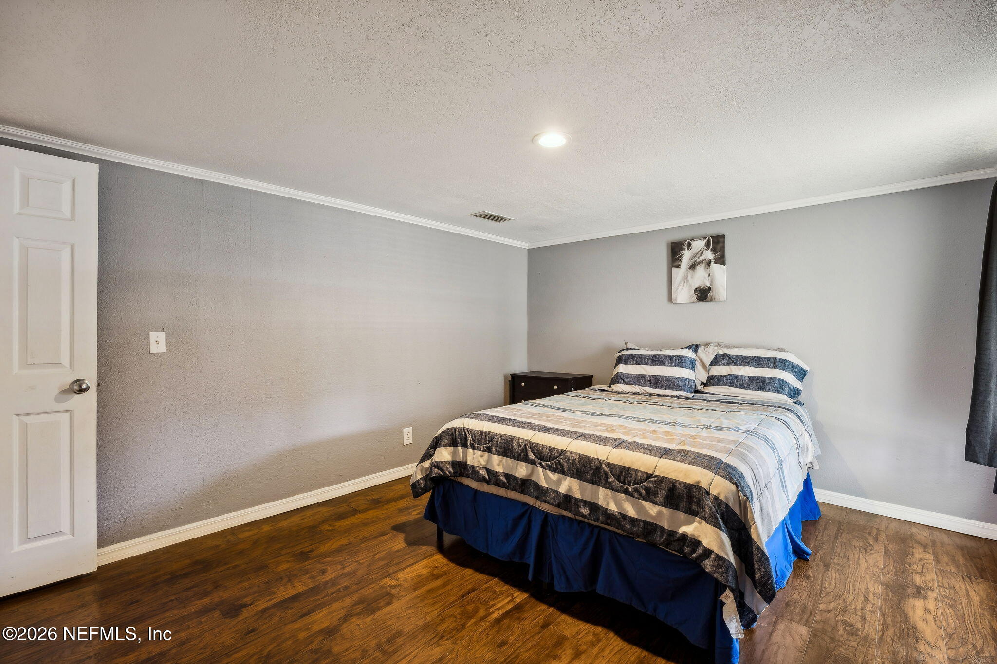 8117 Northwest County Road, Unit 225 Raiford, FL 32083 - Photo 21 of 38 a bedroom with a bed and wooden floor