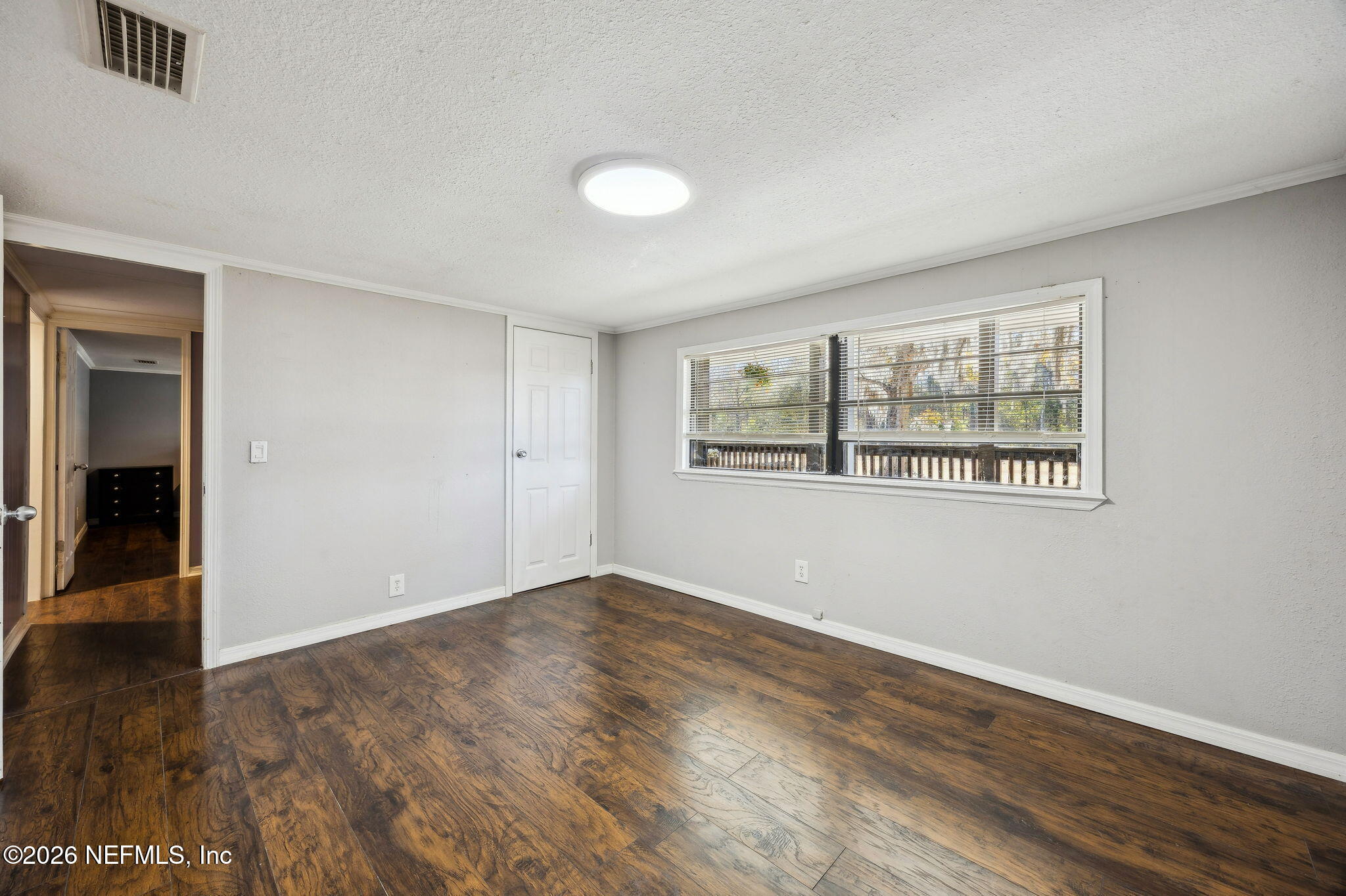 8117 Northwest County Road, Unit 225 Raiford, FL 32083 - Photo 22 of 38 an empty room with wooden floor and windows
