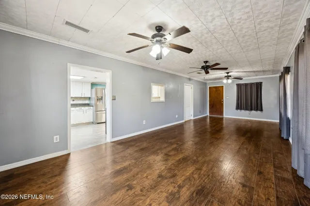 a view of a livingroom with wooden floor and a ceiling fan