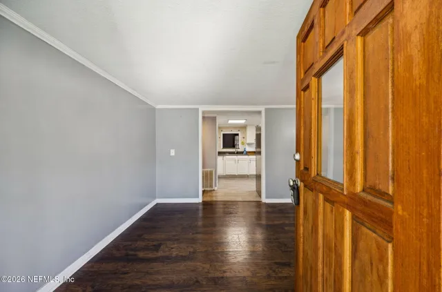 a view of empty room with wooden floor and window