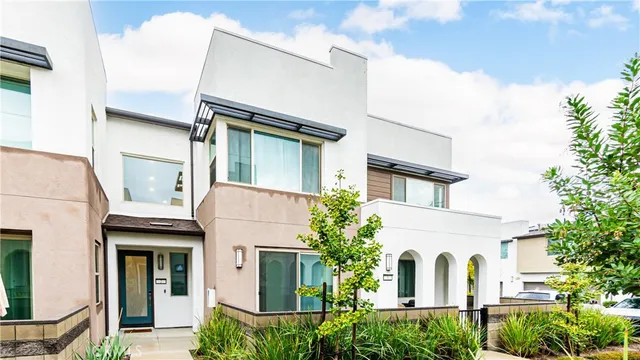 a view of a white house with large windows and a small yard