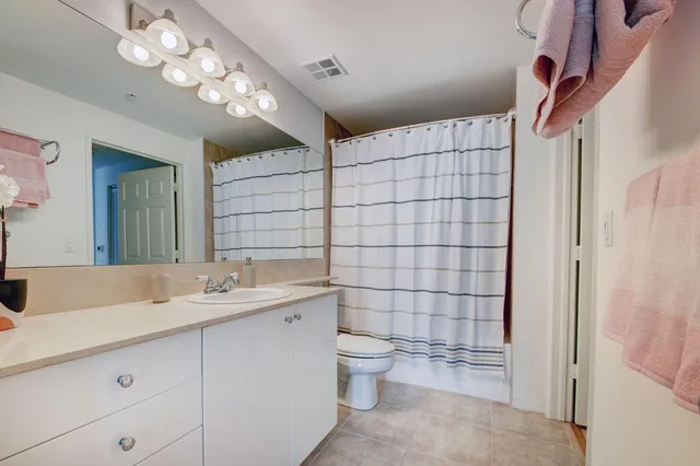 a bathroom with a double vanity sink mirror and toilet