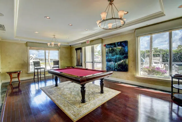 a room with furniture pool table wooden floor and window