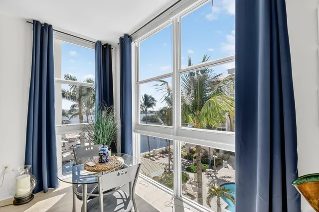 a view of a dining room with furniture large windows and wooden floor