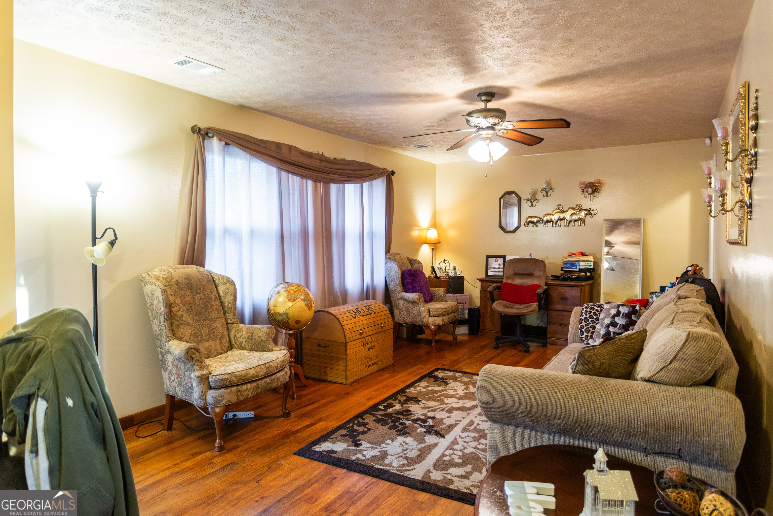 338 Boxwood Street Social Circle, GA 30025 - Photo 5 of 22 a living room with furniture and a chandelier