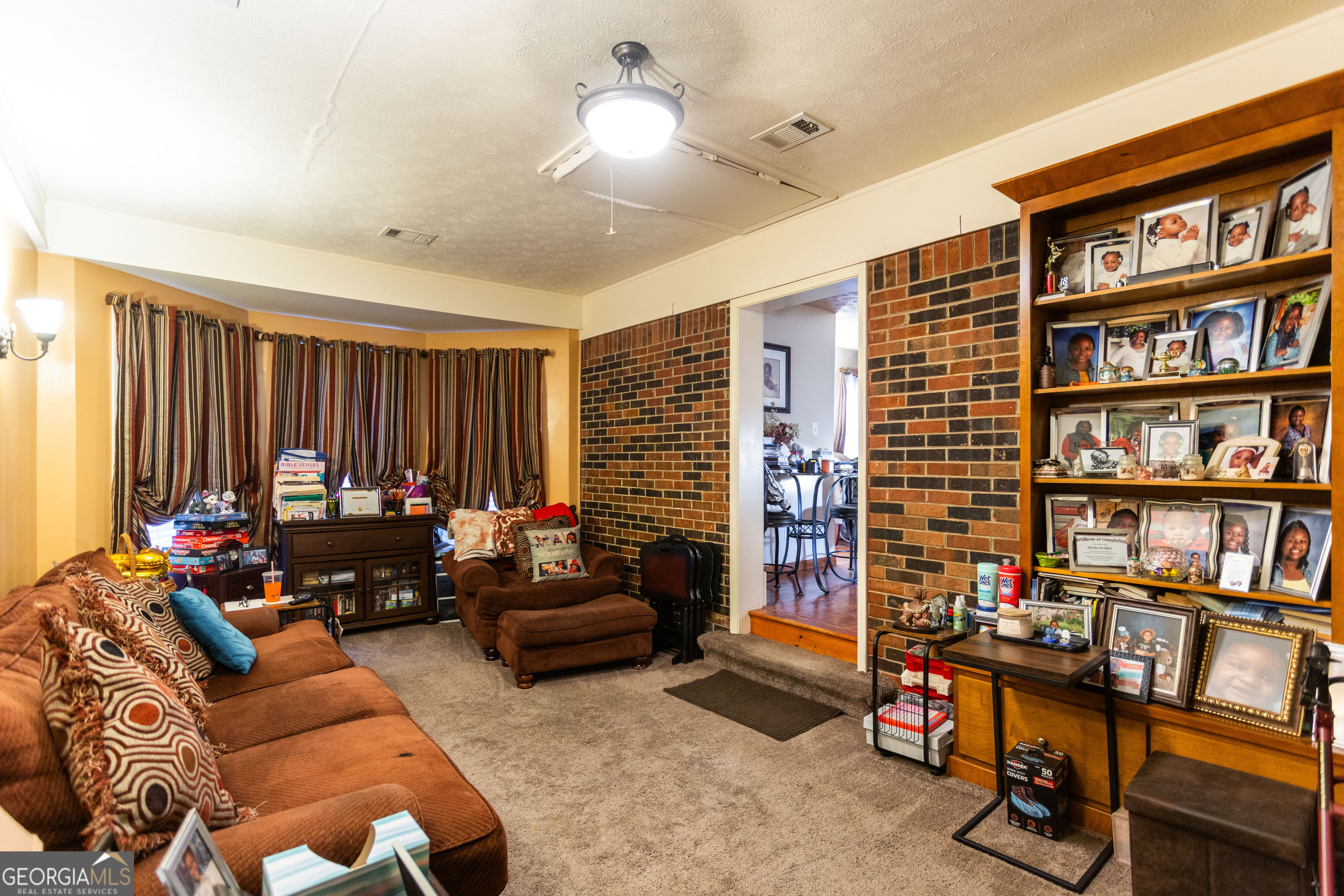 338 Boxwood Street Social Circle, GA 30025 - Photo 8 of 22 a living room with furniture a rug and a book shelf