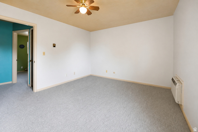285 West 600 North, Unit 2 Logan, UT 84321 - Photo 10 of 21 Spacious room featuring light grey carpeting, white walls, and a light tan ceiling with a brass-finish ceiling fan