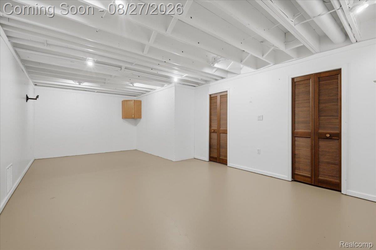 10100 Springtime Circle Clarkston, MI 48348 - Photo 53 of 73 Expansive room featuring painted exposed ceiling joists, light-toned flooring, white walls, and two built-in doors with wood-finish louvered panels