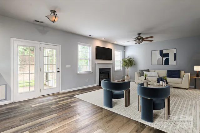 a living room with furniture a fireplace and a flat screen tv