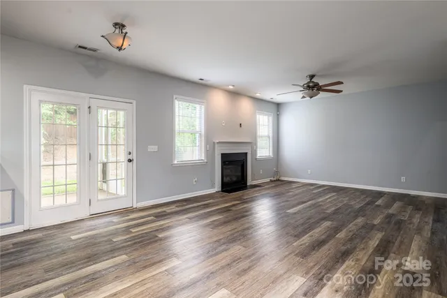 wooden floor fireplace and windows in an empty room