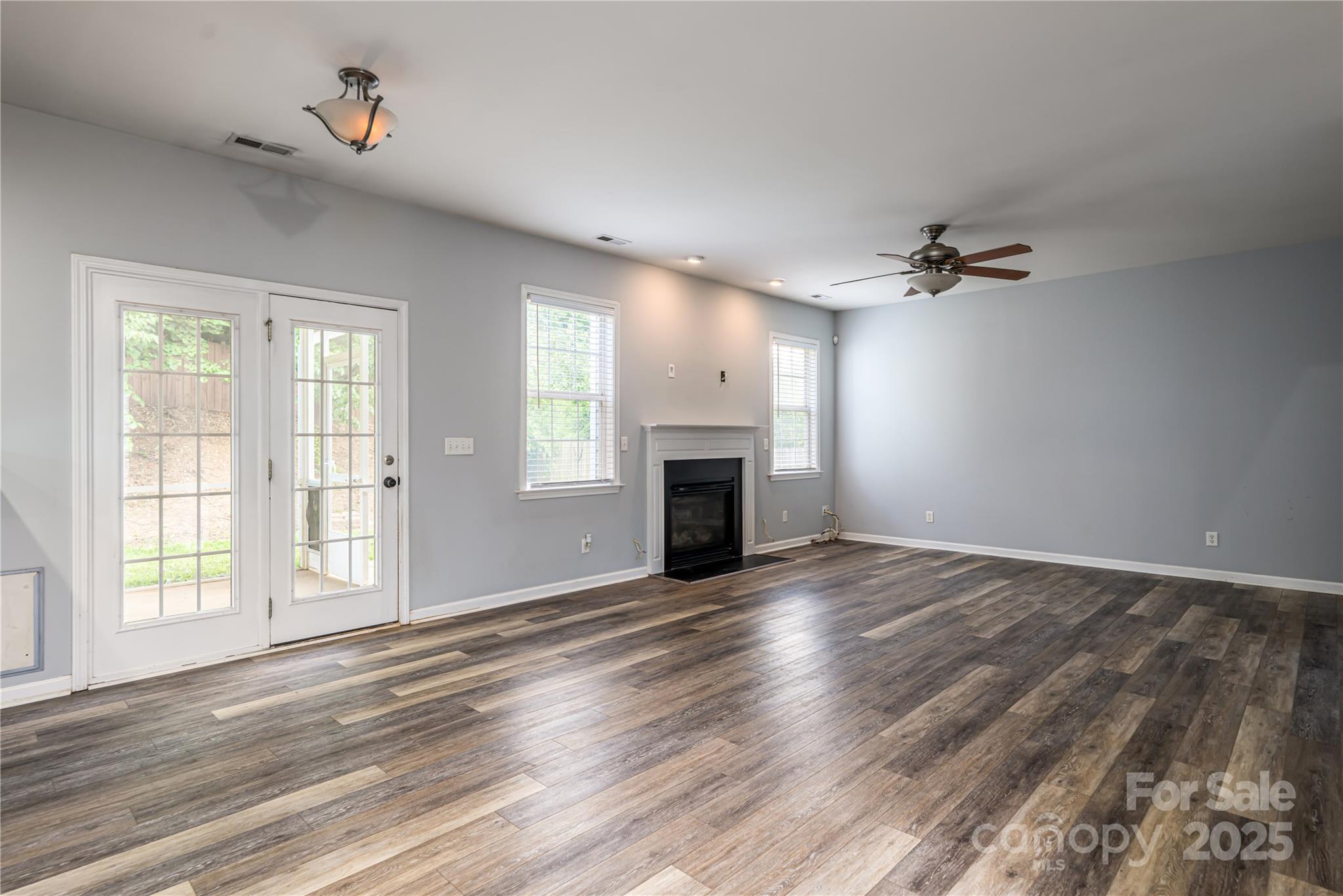 163 Yadkin Road Fletcher, NC 28732 - Photo 13 of 43 wooden floor fireplace and windows in an empty room