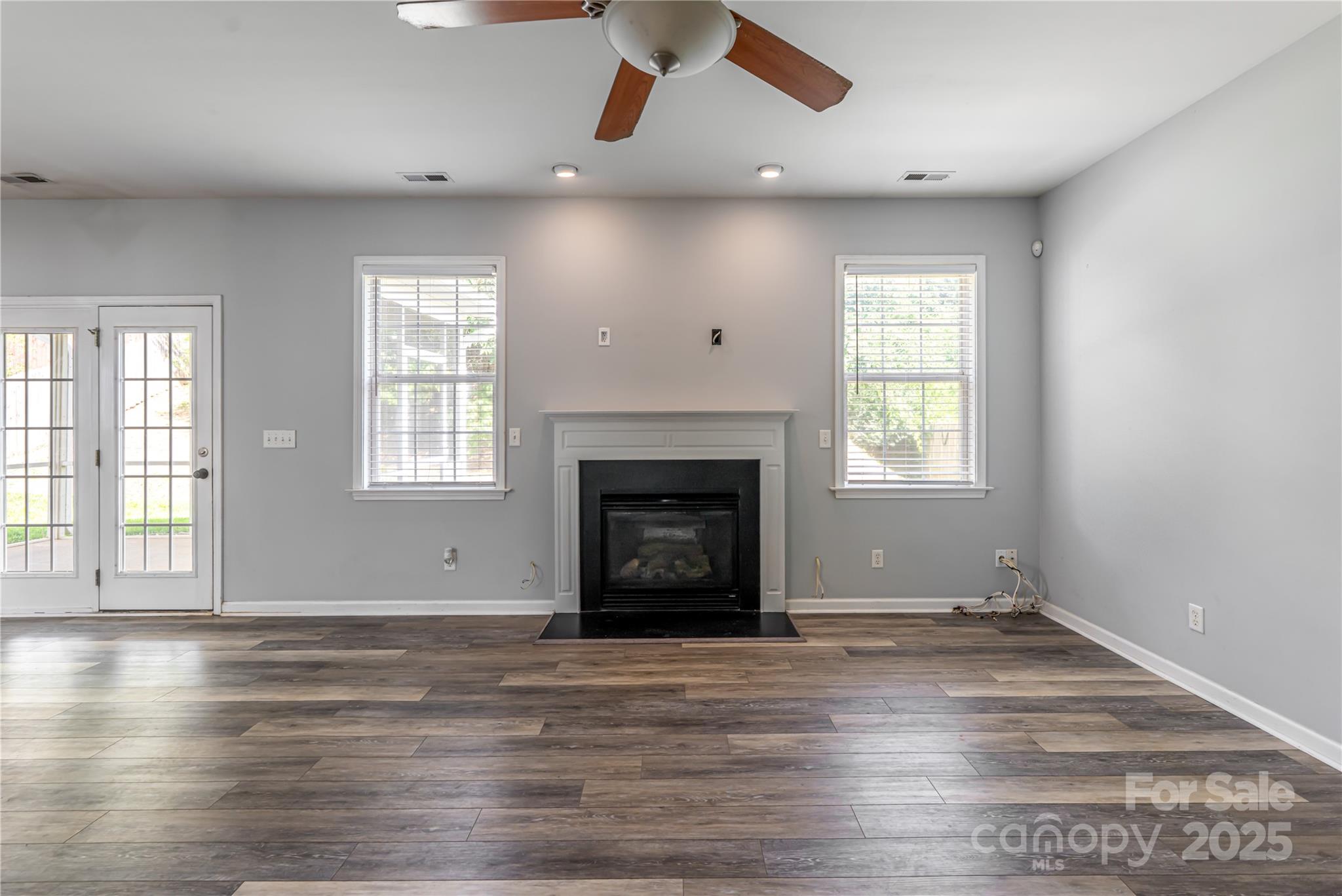 163 Yadkin Road Fletcher, NC 28732 - Photo 14 of 43 an empty room with wooden floor fireplace and windows