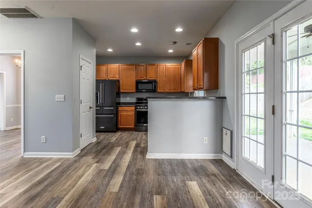 a view of kitchen with stainless steel appliances granite countertop a refrigerator and a sink