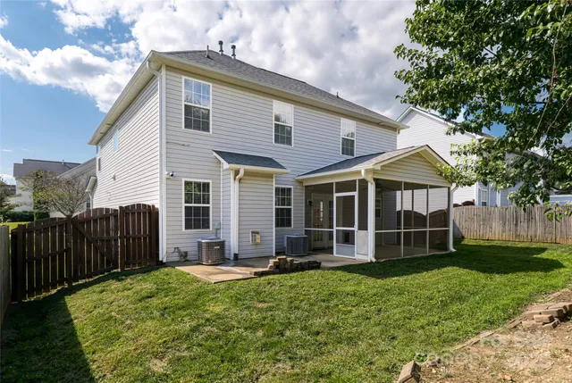 a view of a house with wooden fence and a yard