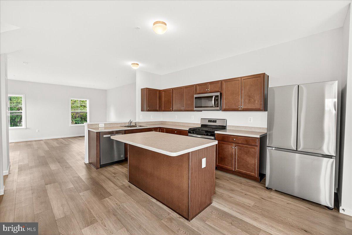 1600 Corn Crib Place Frederick, MD 21702 - Photo 17 of 38 a kitchen with stainless steel appliances granite countertop a stove top oven a refrigerator a sink and dishwasher with wooden floor