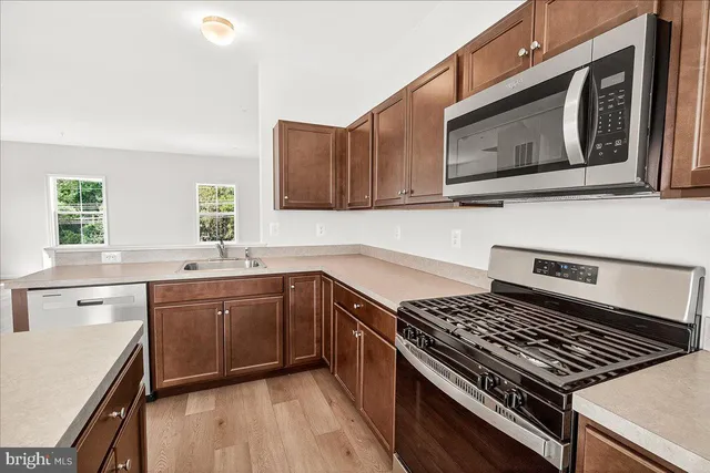 a kitchen with stainless steel appliances granite countertop a stove a sink and a microwave