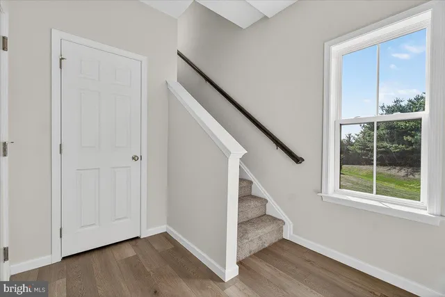 a view of entryway with wooden floor and stairs