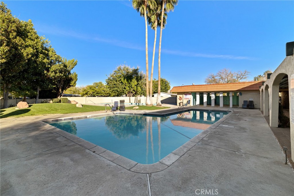 3524 East Avenue R, Unit 121 Palmdale, CA 93550 - Photo 32 of 40 a view of a swimming pool with a lounge chair