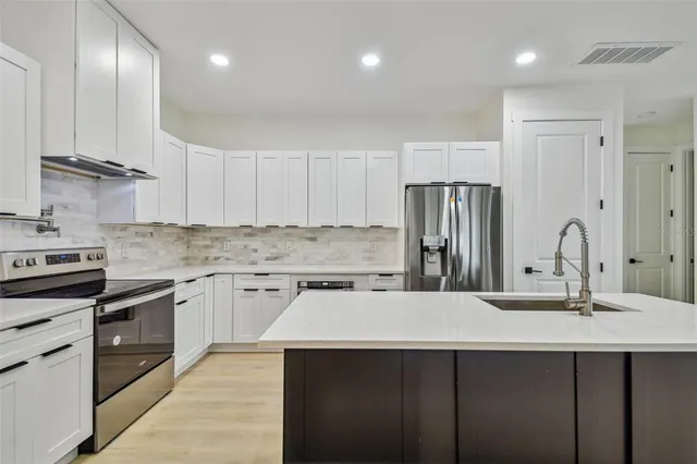 a kitchen with a refrigerator sink and stainless steel appliances