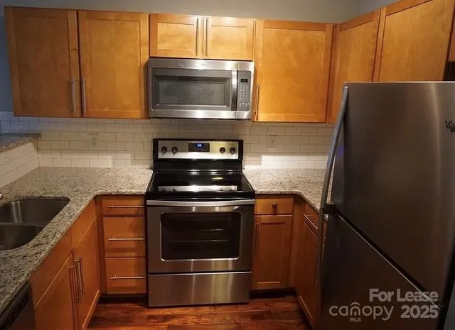 a kitchen with stainless steel appliances wooden cabinets stove and microwave
