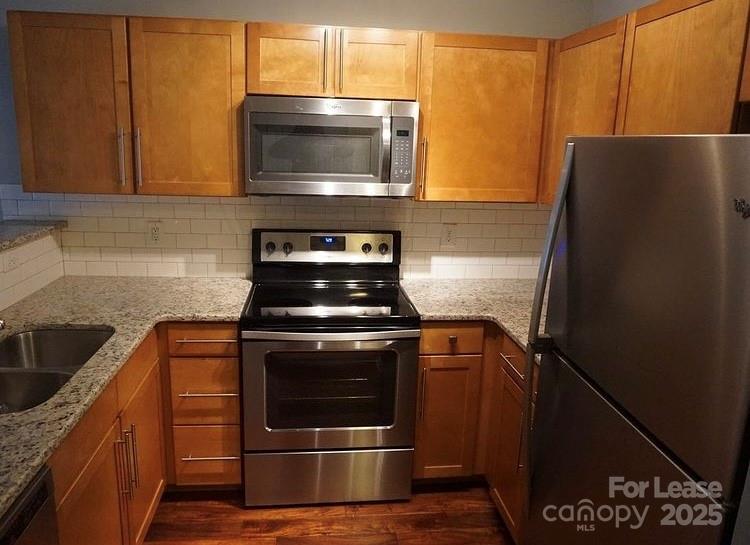 1310 Fleming Road, Unit P Greensboro, NC 27410 - Photo 2 of 12 a kitchen with stainless steel appliances wooden cabinets stove and microwave