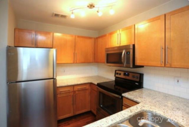1310 Fleming Road, Unit P Greensboro, NC 27410 - Photo 3 of 12 a kitchen with granite countertop a refrigerator and a stove top oven