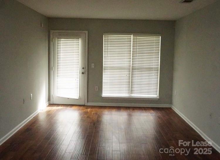 1310 Fleming Road, Unit P Greensboro, NC 27410 - Photo 7 of 12 a view of an empty room with wooden floor and a window