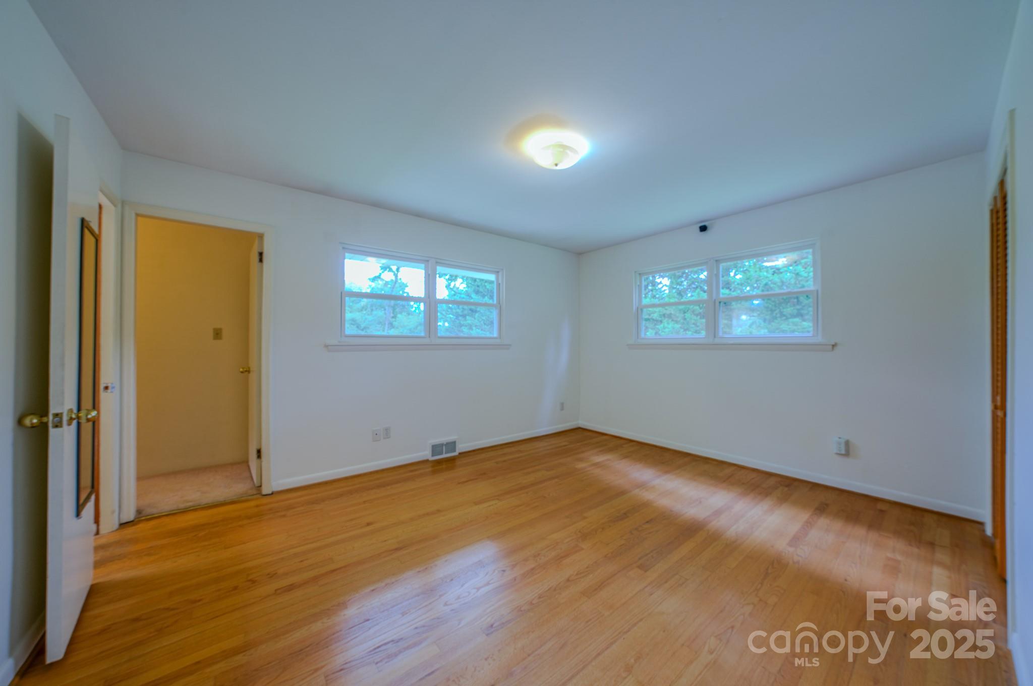 26 Big Cove Road Candler, NC 28715 - Photo 23 of 47 a view of an empty room with wooden floor and a window