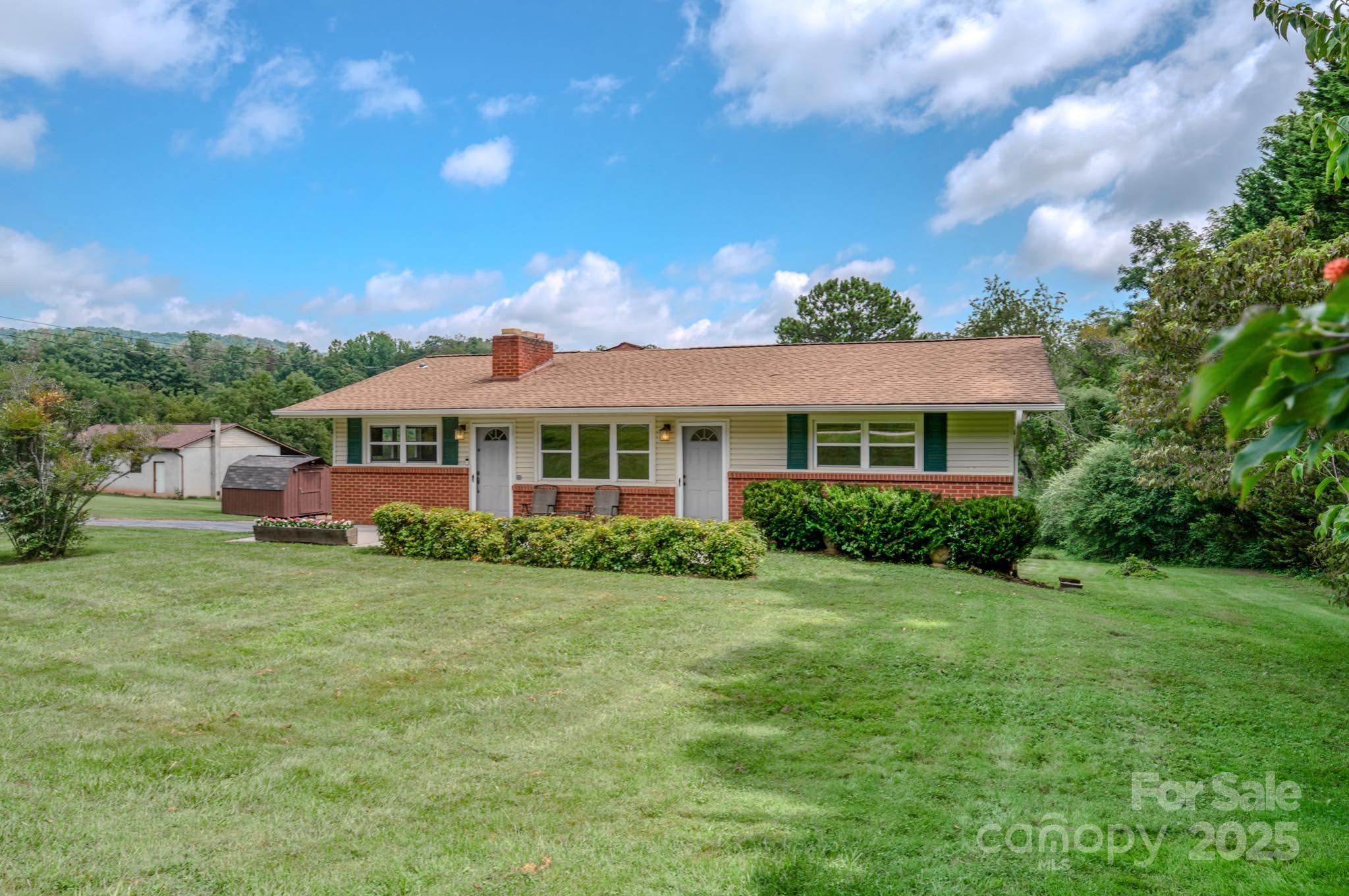 26 Big Cove Road Candler, NC 28715 - Photo 4 of 47 a front view of a house with a garden