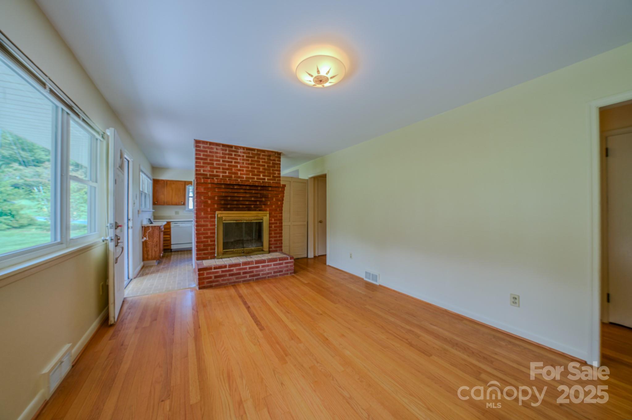 26 Big Cove Road Candler, NC 28715 - Photo 7 of 47 a view of an empty room with a fireplace and a window
