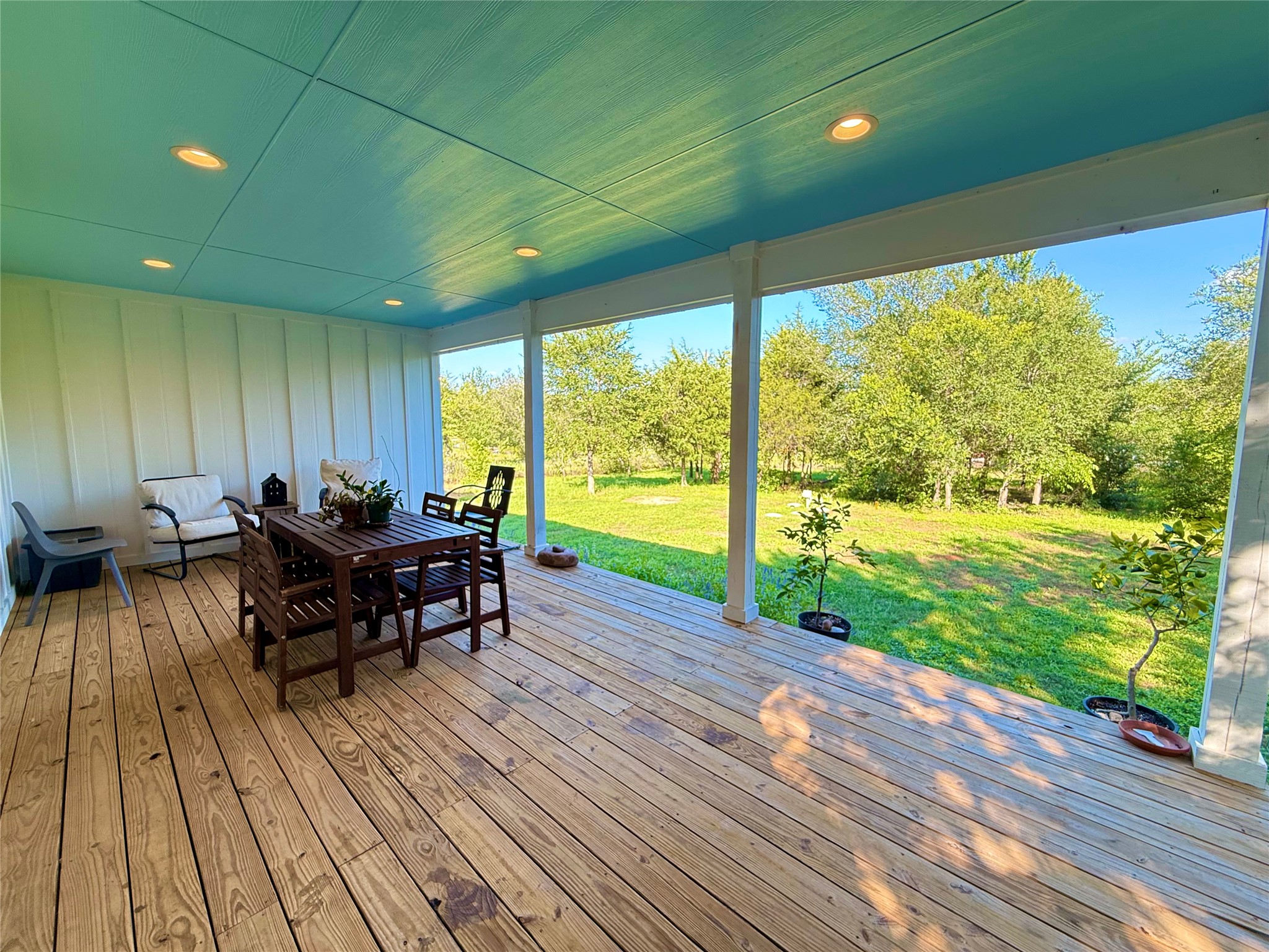 739 Pleasant Grove Road Elgin, TX 78621 - Photo 21 of 29 Expansive covered wood-finish deck with a vibrant blue ceiling and recessed lighting