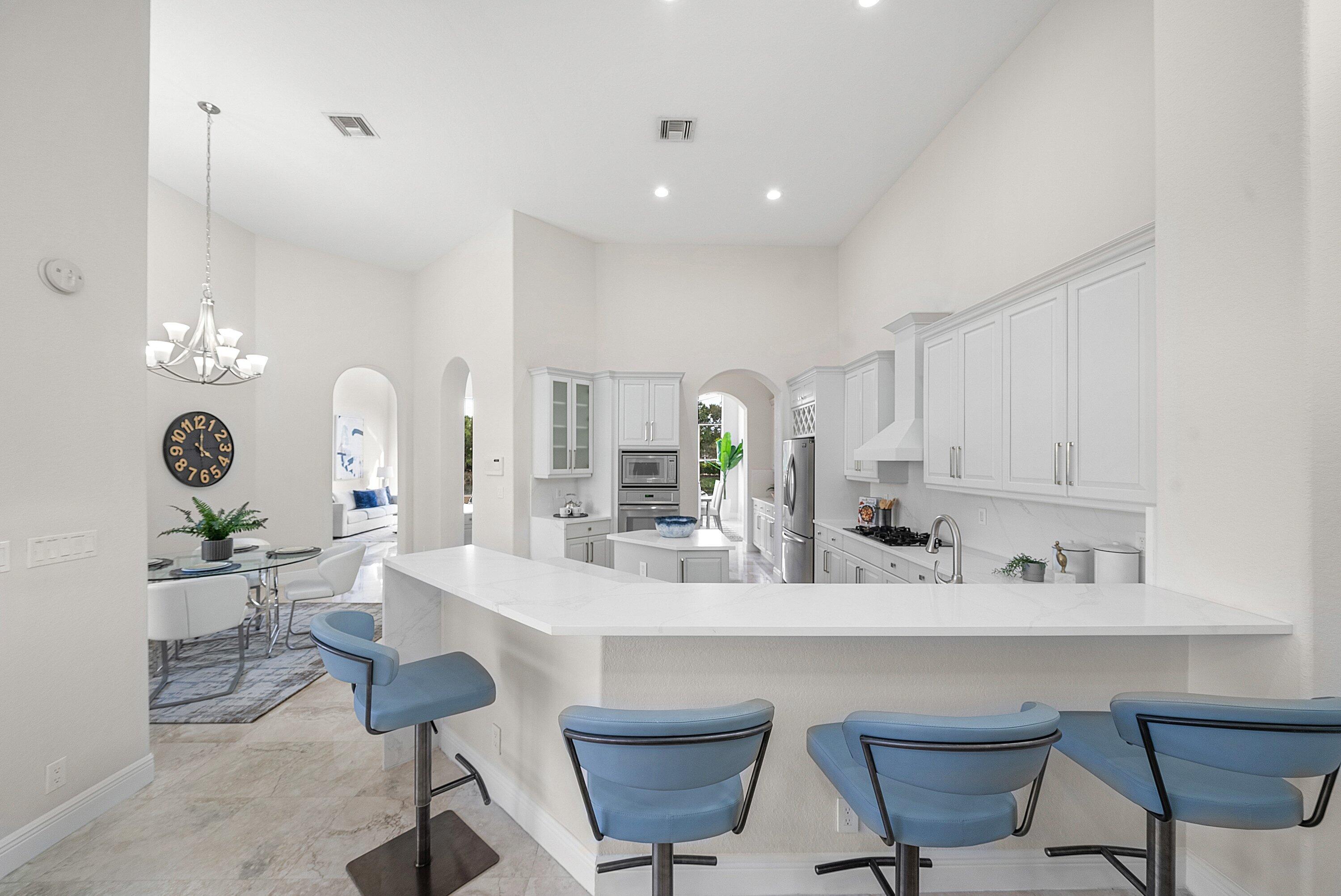 6468 Polo Pointe Way Delray Beach, FL 33484 - Photo 16 of 89 a kitchen with stainless steel appliances a dining table chairs and cabinets