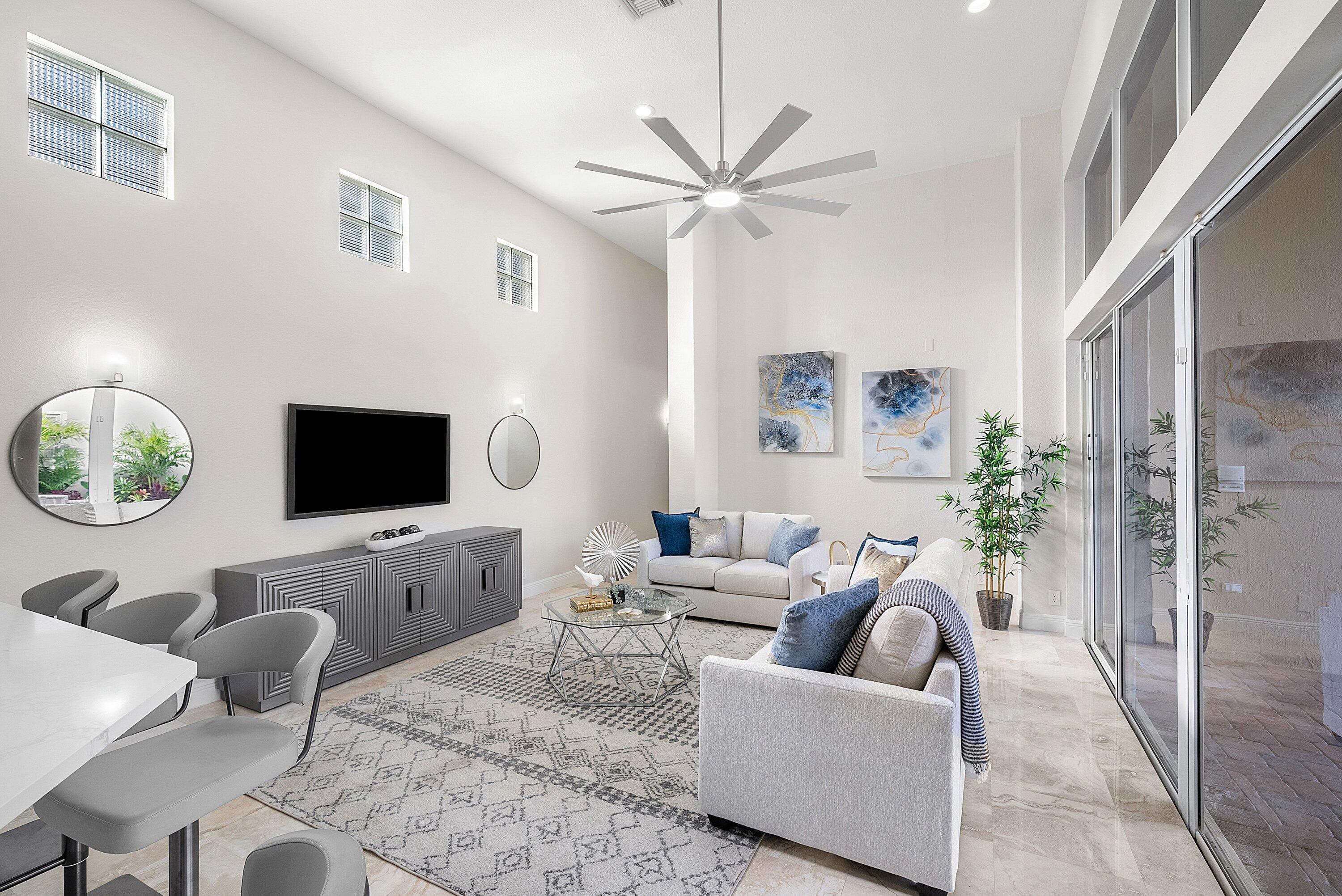 6468 Polo Pointe Way Delray Beach, FL 33484 - Photo 19 of 89 a living room with furniture a flat screen tv and a window