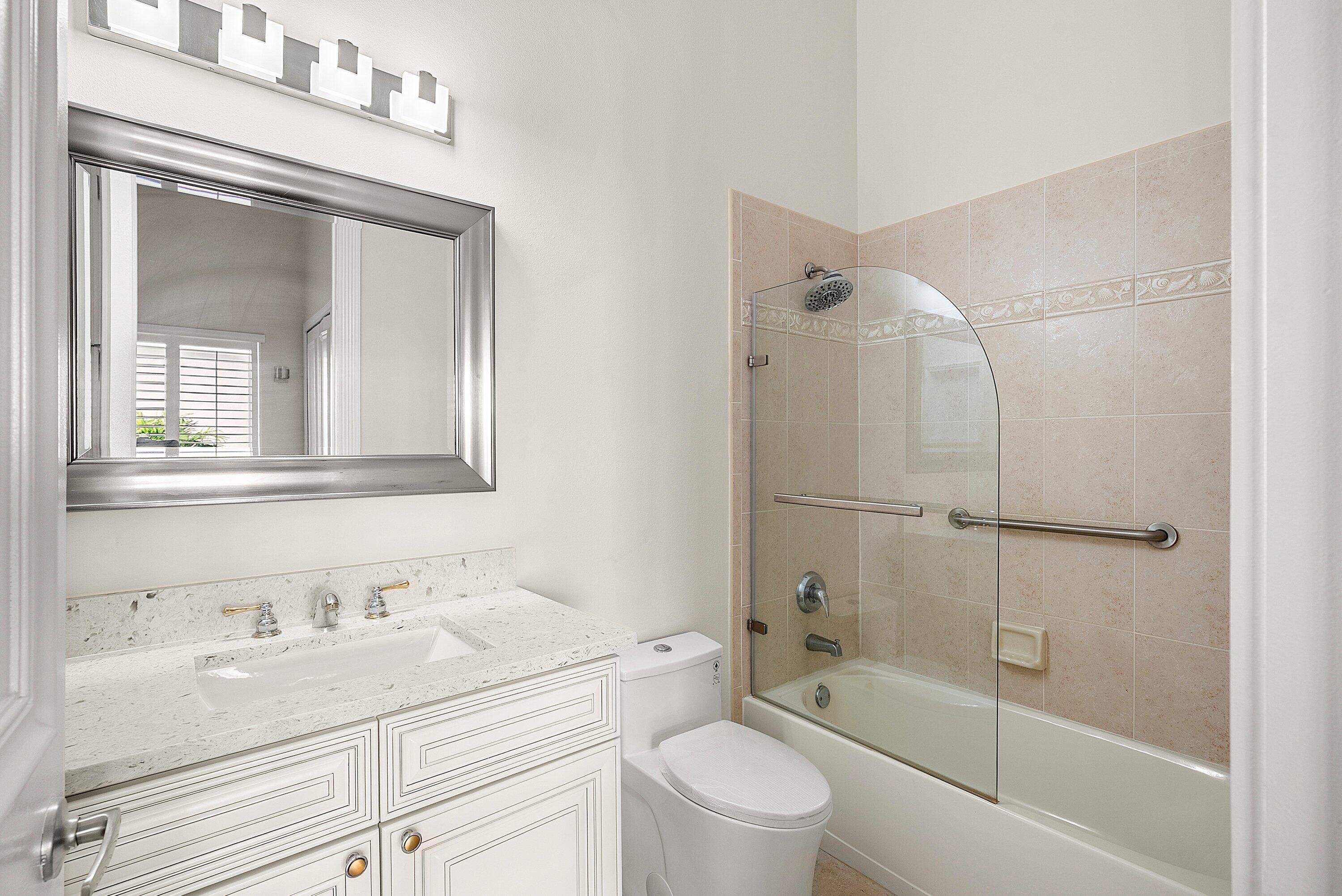 6468 Polo Pointe Way Delray Beach, FL 33484 - Photo 32 of 89 a bathroom with a granite countertop sink a toilet and shower