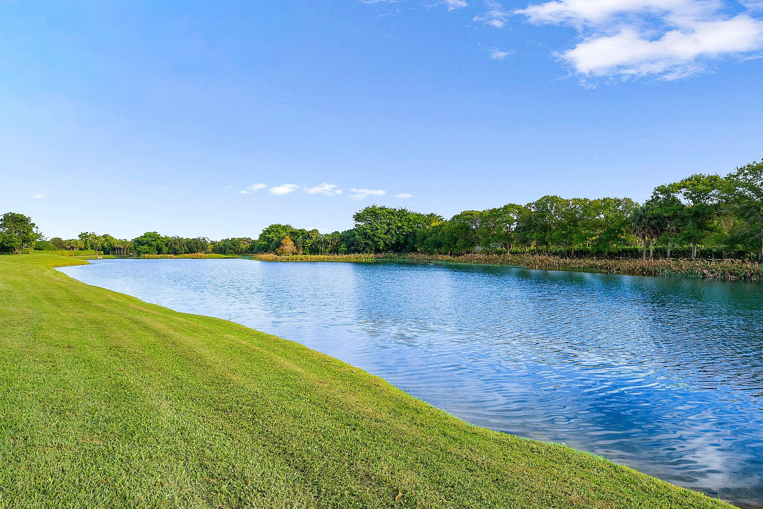 6468 Polo Pointe Way Delray Beach, FL 33484 - Photo 36 of 89 a view of a lake with houses in the back