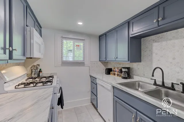 a kitchen with sink a stove and cabinets
