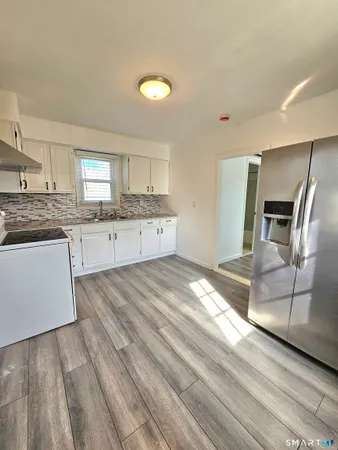 a spacious bathroom with a granite countertop sink a toilet a mirror and vanity