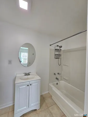 a bathroom with a bathtub a sink and a mirror