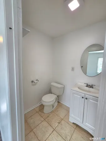 a bathroom with a toilet a sink and mirror