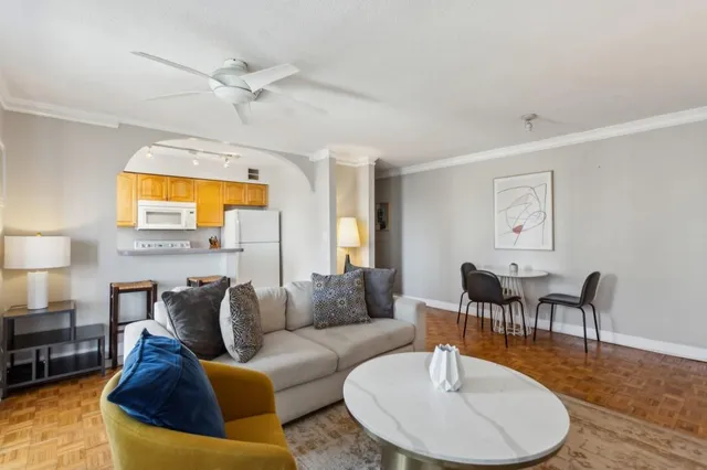 a living room with furniture and a wooden floor