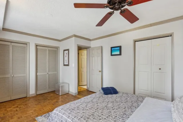 a bedroom with a bed and a chandelier fan