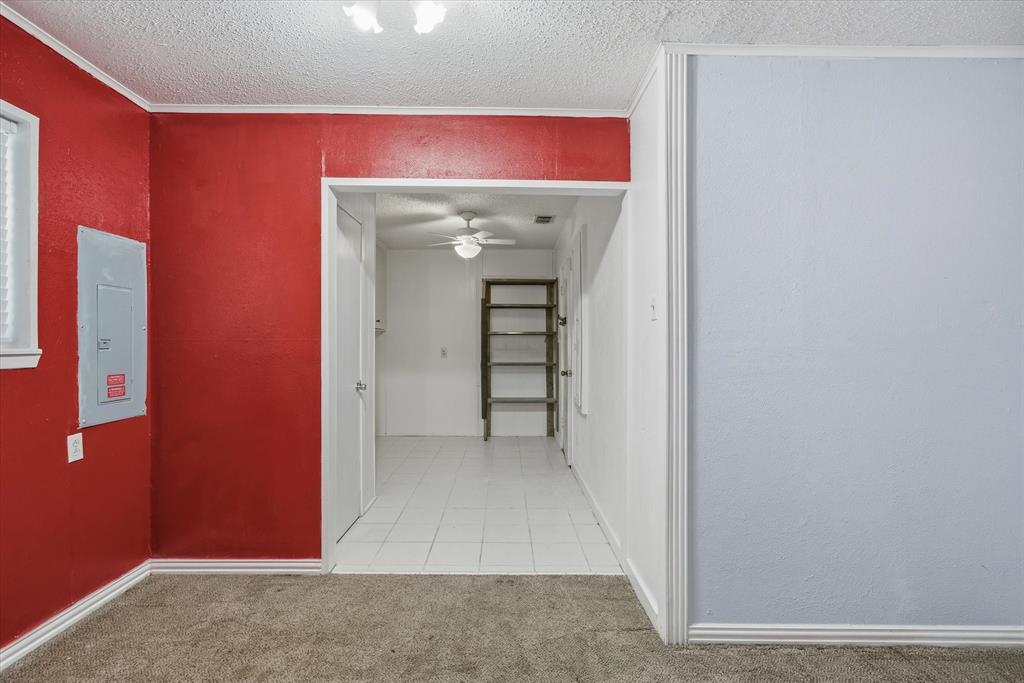 1729 Elliot Drive Canton, TX 75103 - Photo 14 of 40 Hallway with a textured ceiling, light carpet, electric panel, light tile patterned floors, and a textured wall
